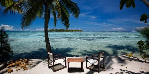 Chairs and table on empty beach in Tahiti