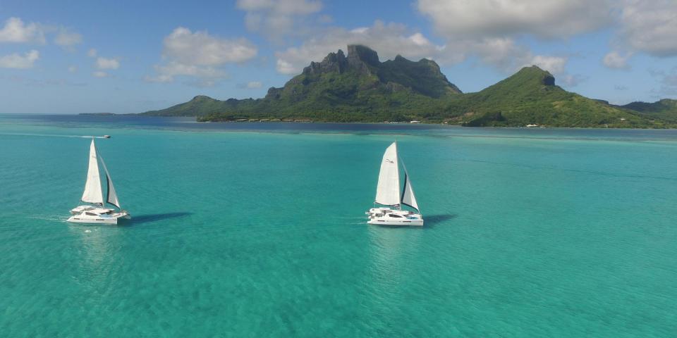 Two sailing catamarans in Tahiti Two sailing catamarans in Tahiti
