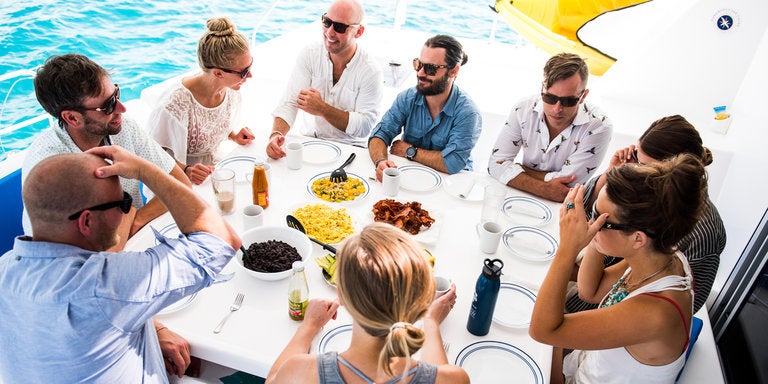 grupo comiendo en la cubierta de un yate